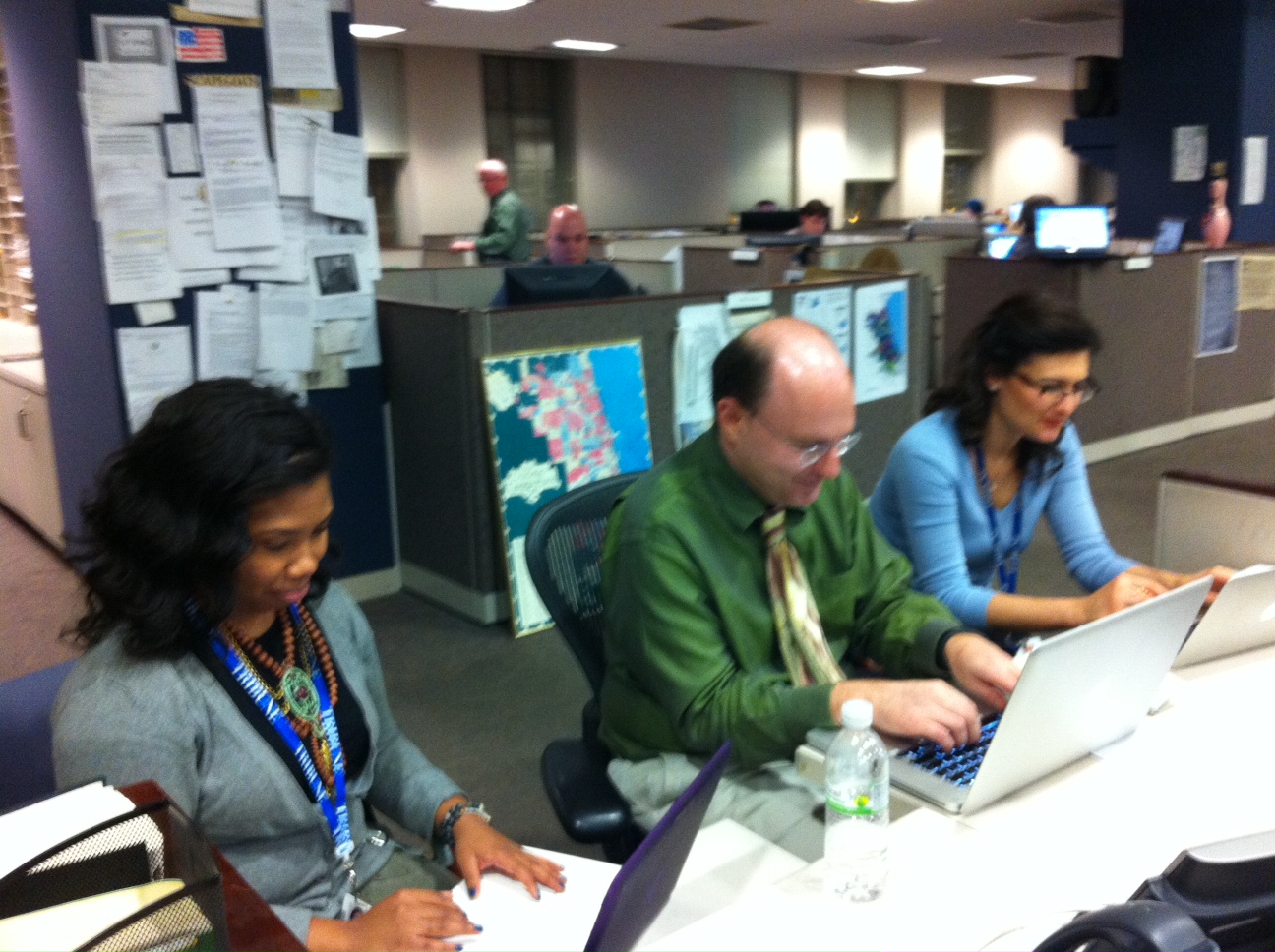 Journalists working at computers in a newspaper newsroom.